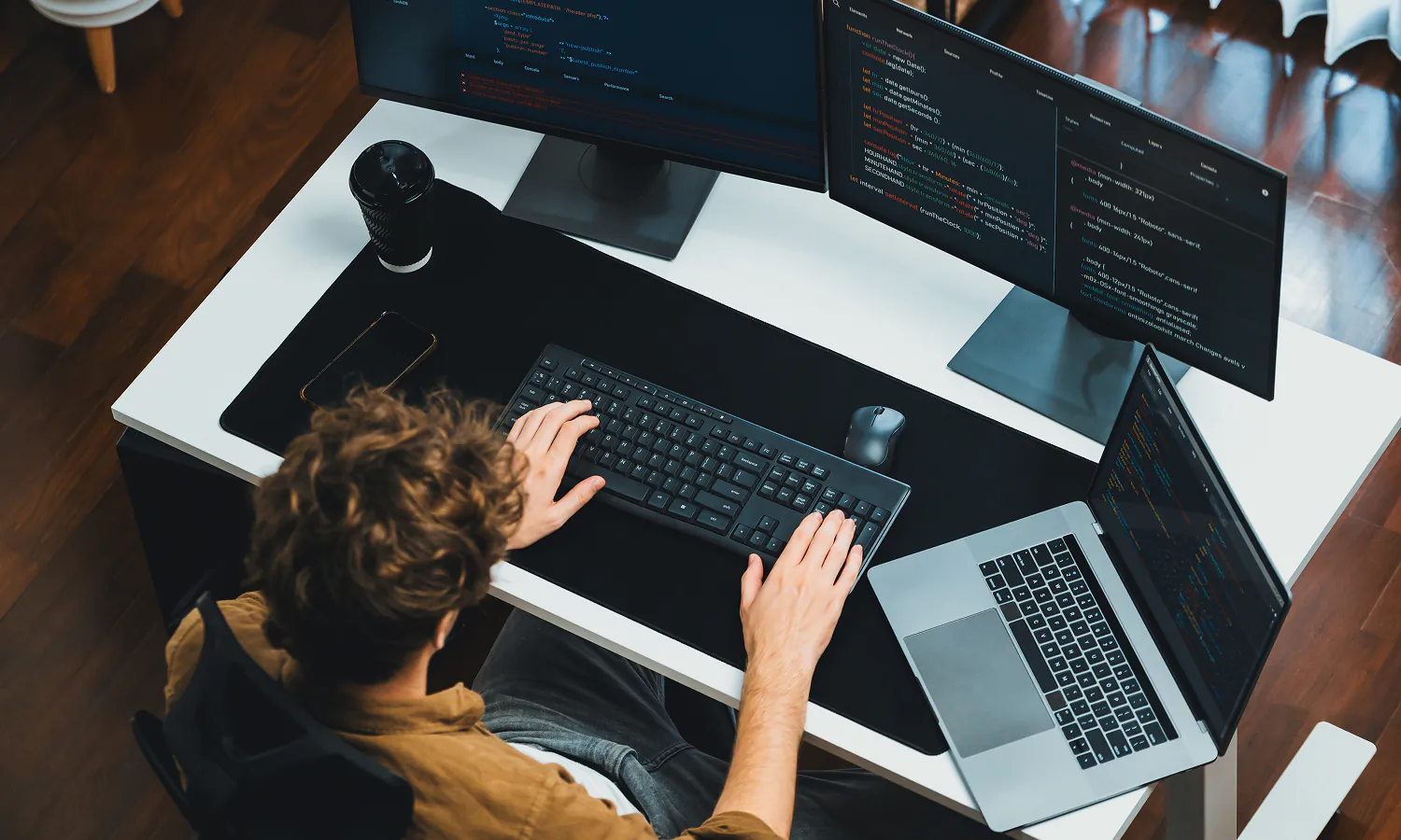 Coding and programming on a computer at a modern workspace.