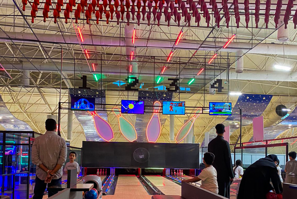 Indoor bowling alley featuring digital scoring monitors and vibrant neon lighting for an exciting ga.