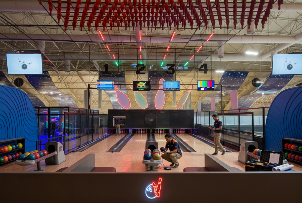 Brightly lit bowling lanes with digital scoreboards and vibrant decor.